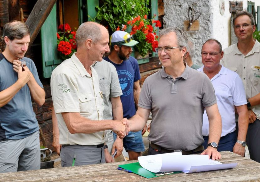 Herbert Wölger (Geschäftsführer Natioanlark Gesäuse) und Peter Riedler (Rektor Universität Graz) unterzeichnen feierlich die Kooperationsvereinbarung auf der Kölblalm